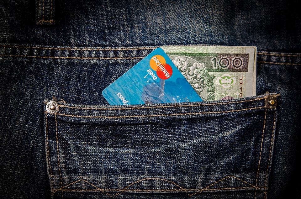 Credit card and 100-dollar banknote in a denim jeans pocket, representing affordable SEO budget