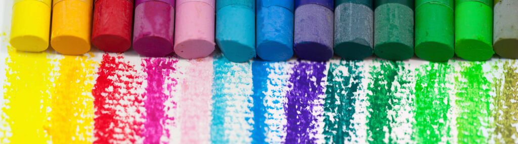 Colorful pastel chalk sticks with rainbow powder strokes